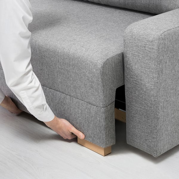 Person is assembling GRÄLVIKEN sofa-bed, showing storage compartment.