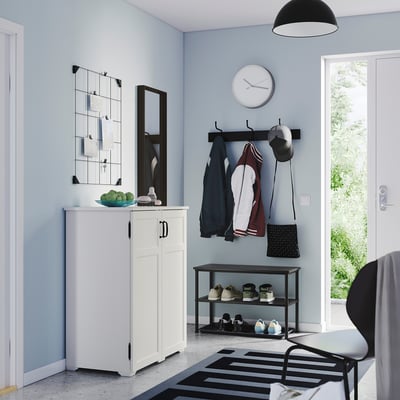 Modern entryway with white cabinet, shoe rack, and coat hooks; black and white decor.