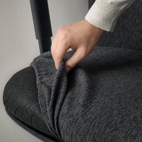 Hand adjusting ergonomic office chairs armrest. Dark fabric, modern design.