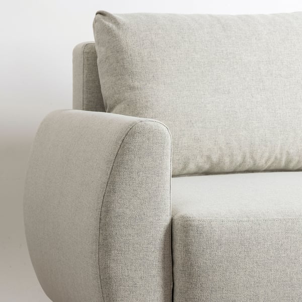 Modern sofa in light grey fabric, showcasing clean lines and sturdy upholstery. Close-up highlights comfortable, rounded armrest and backrest.