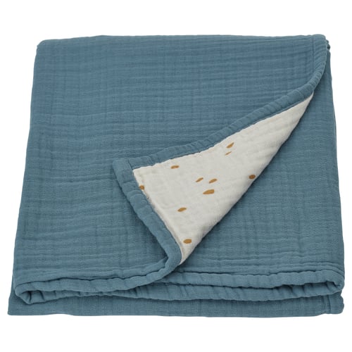 A blue GULDVÄVARE baby blanket with a white patterned side, folded. Made of organic cotton muslin.