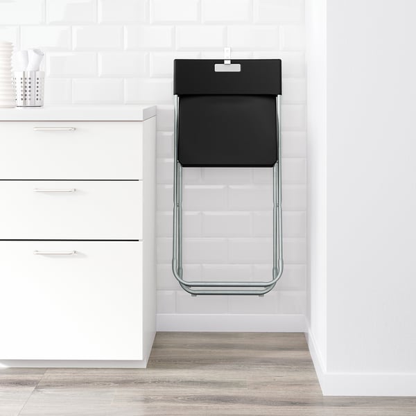 Foldable chair hangs on wall, saves space. Locks open, holds 100 kg.