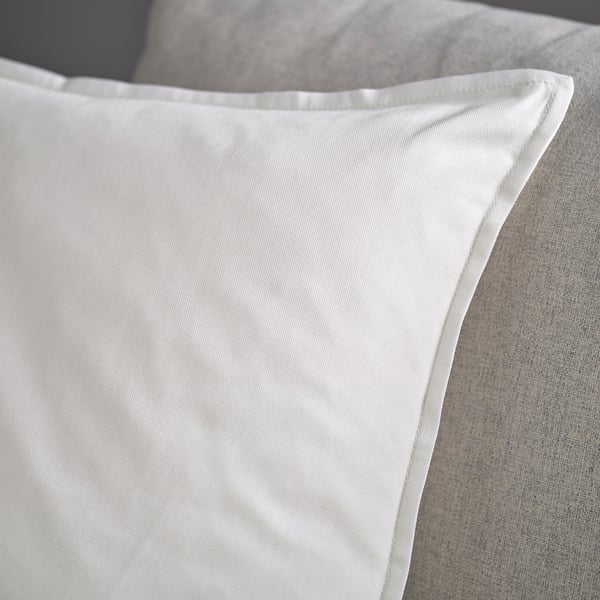 White pillowcase on a couch, showcasing smooth, high-quality fabric with a neat zip.
