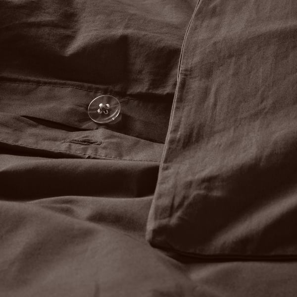 Close-up of button on brown duvet, showing crisp cotton texture.