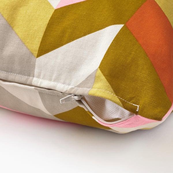 Close-up of geometric-patterned cushion with opened zip, showcasing inner mesh and stitching.