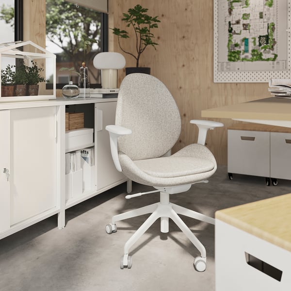 Modern office setup with ergonomic chair, wooden desk, white cabinets.