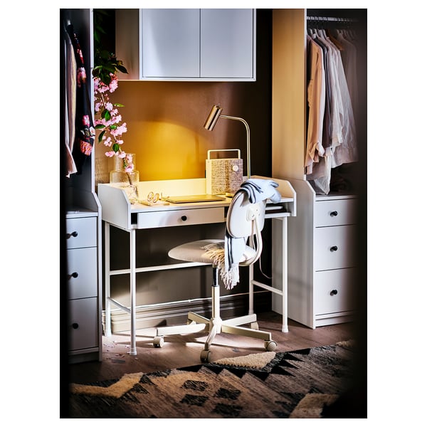 Home office setup: white HAUGA desk with chair, lamp, and drawers. Clean, modern design with storage.