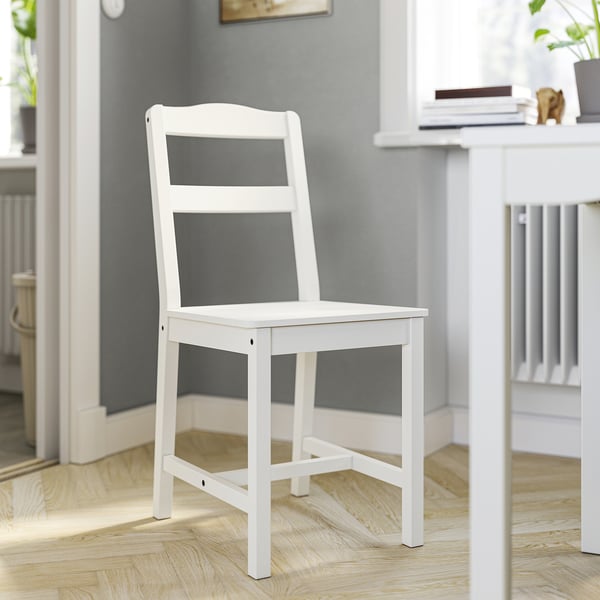 White HAUGA chair, minimalist design, wooden material, used in dining area.
