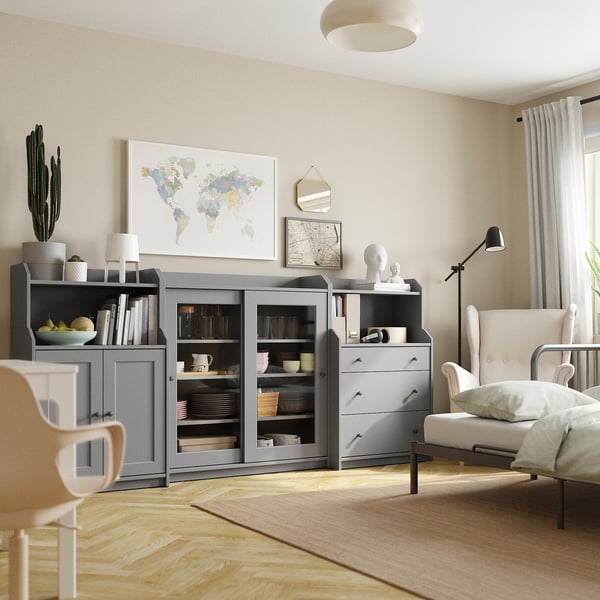 Contemporary living room HAUGA grey shelves and cabinets storing dishes and books, accented with global maps and a cosy white couch.