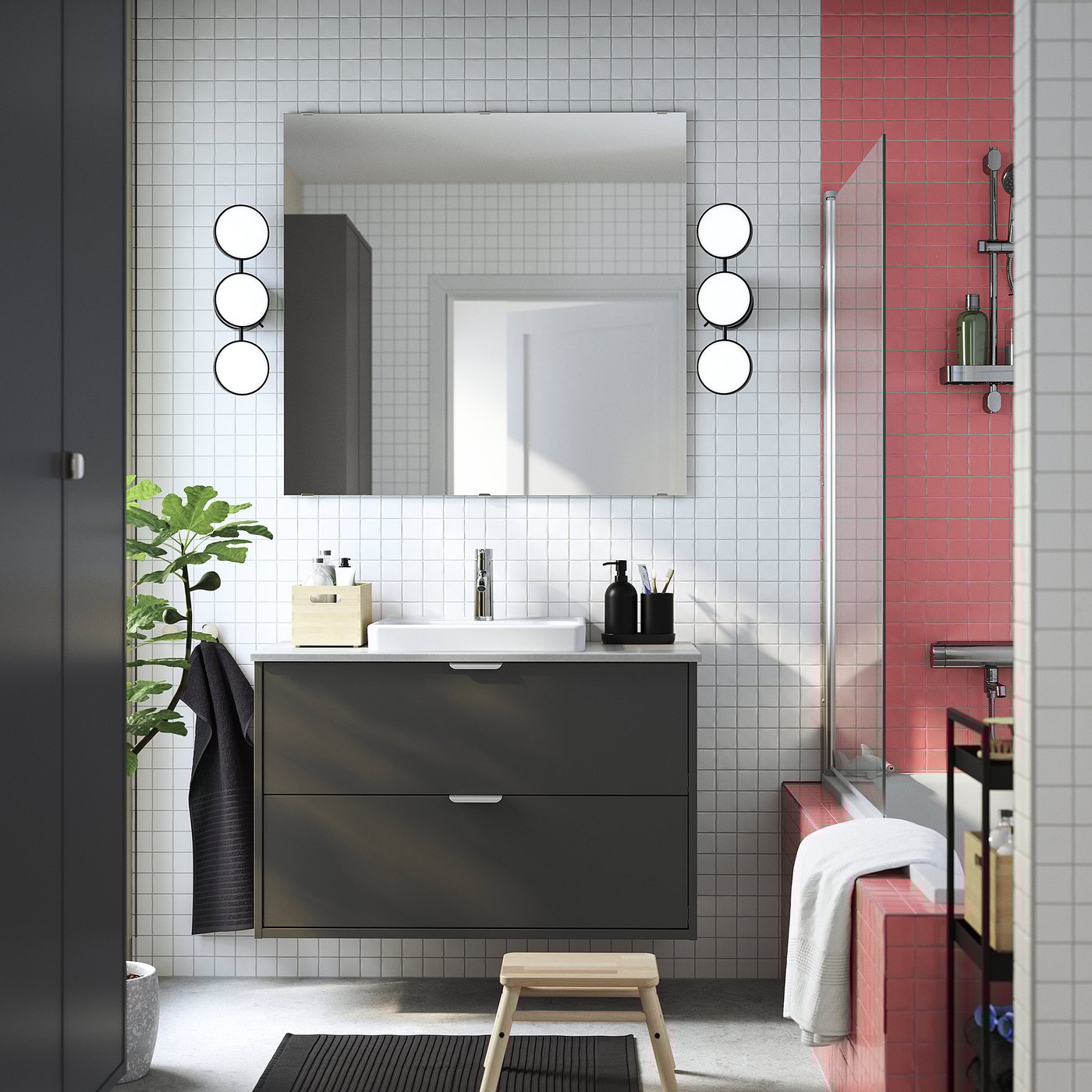 Contemporary bathroom HAVBÄCK dark grey vanity with drawer and sink. Round mirrors and red-tiled shower enhance modern design.
