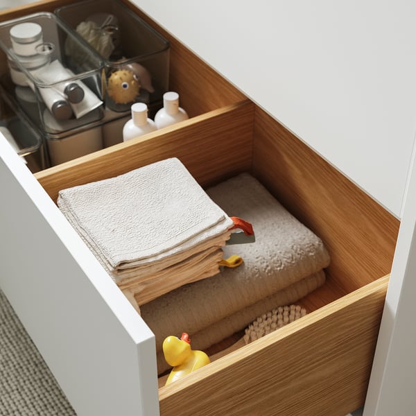 This image shows a clean, organised bathroom drawer with neatly folded towels and a toy duck, part of the HAVBÄCK series.