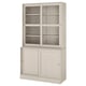 A light beige HAVSTA storage cabinet. It glass doors at the top and wooden cabinets below. The design is rustic with a brushed pine finish.