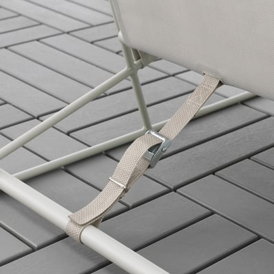 Grey outdoor chair withabeige strap and metal frame, shown on wooden deck.