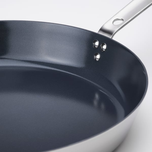 Non-stick frying pan with stainless steel handle, sol-gel ceramic coating for even heat distribution.