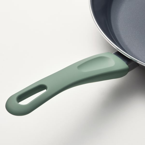 Modern pan with ergonomic, green silicone handle offering secure grip and heat resistance.