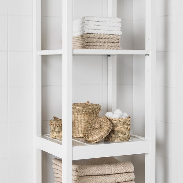 White bathroom shelf with neatly folded towels and woven baskets.