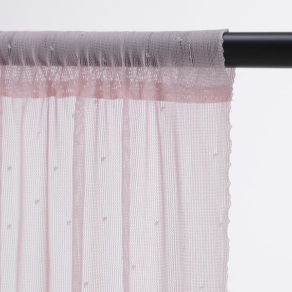 Sheer fabric curtains hang on black rod, allowing light to philtre through while offering privacy.