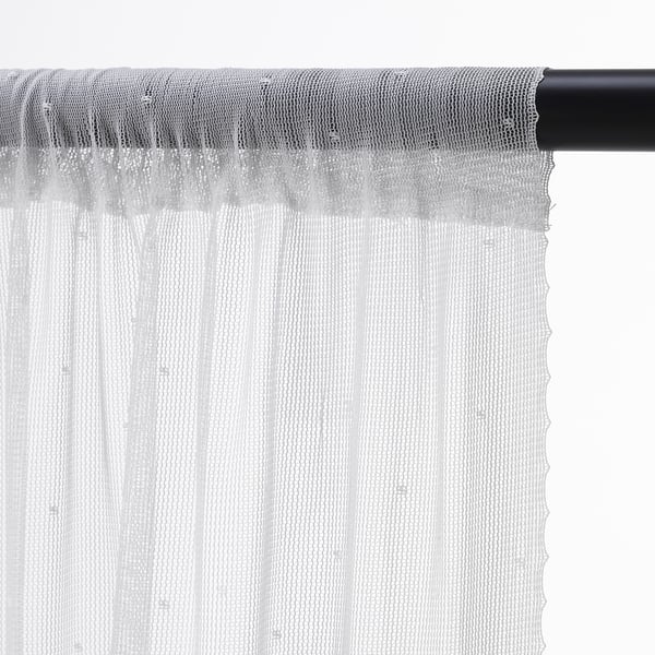 White sheer curtains hanging from black rod, allowing light while providing privacy.
