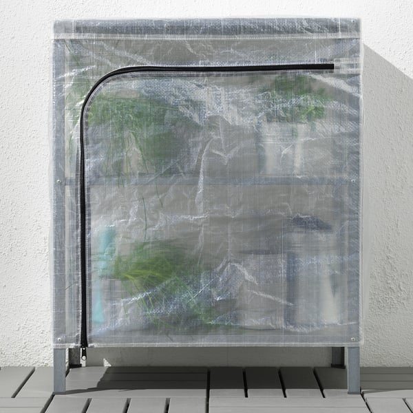Image shows HYLLIS greenhouse cover on shelving unit, protecting plants indoors/outdoors.