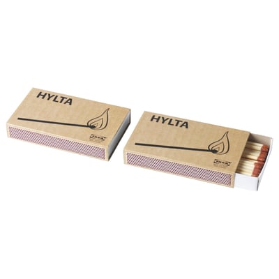 Two brown cardboard matchboxes labelled HYLTA with white matches inside, lying on a white background.
