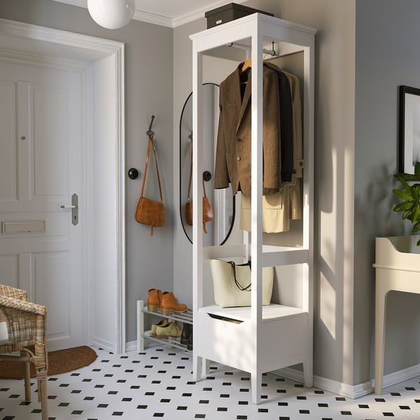 A white IDANÄS open wardrobe with adjustable shelves, holding clothes and accessories in a well-organized entryway.