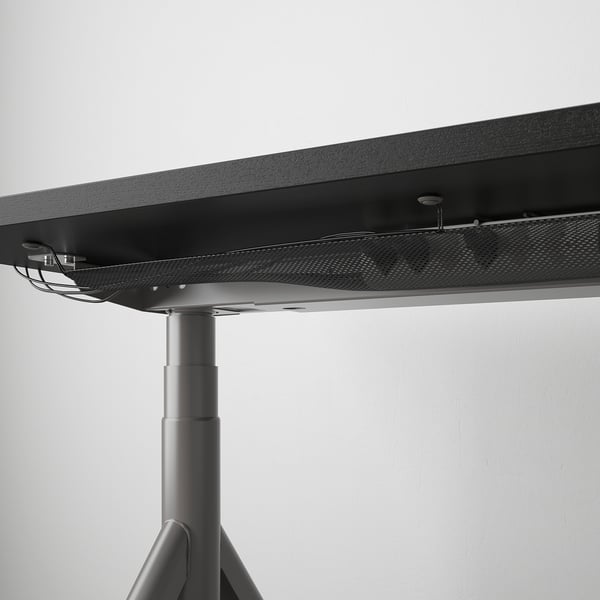 Underneath tabletop, a cable management net keeps cords organised, ensuring a tidy workspace.