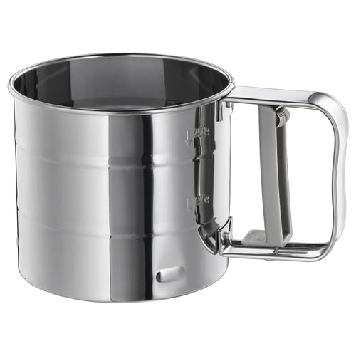 Stainless steel flour sifter, silver, round, handle on right. Smooth surface, 250 g mark visible.