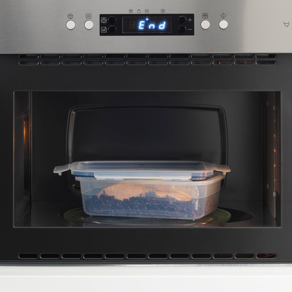 Plastic food container inside microwave; likely reheating leftovers.