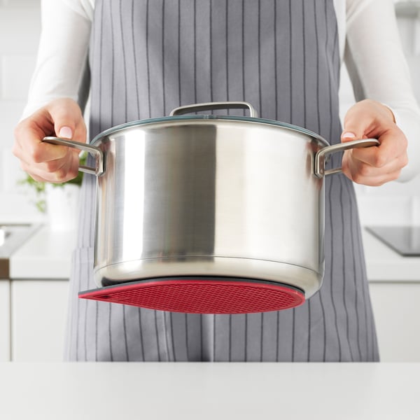 Person cooking on red induction stove
