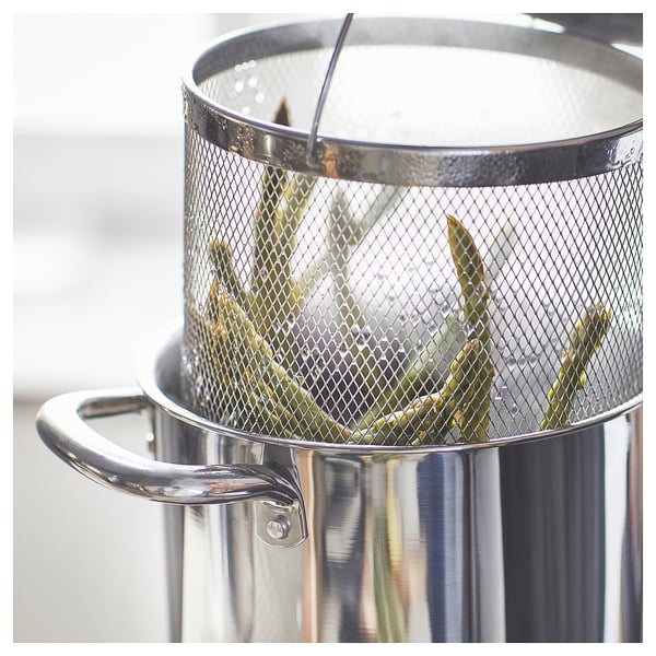 Silver strainer with mesh holding asparagus.