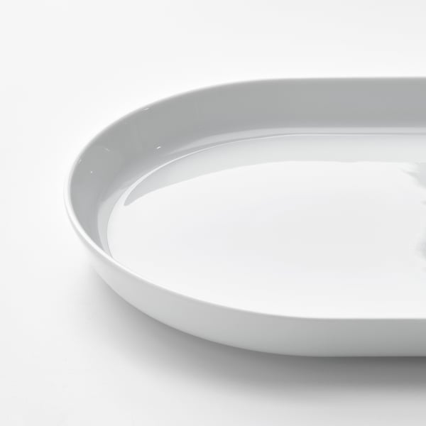 A pristine, round porcelain serving plate with a smooth, glossy finish and a slightly raised edge, demonstrating high-quality craftsmanship.