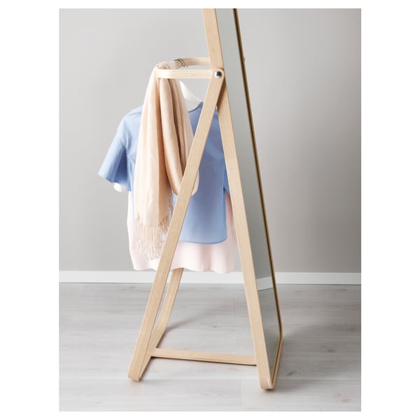 A wooden-framed mirror with a hook holds clothes, saving time by displaying the next days outfit.