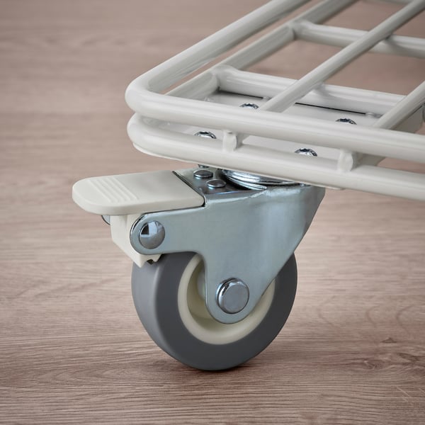 Close-up of a trolley wheel. Shows smooth, durable caster with brake, attached to robust, clean frame, resting on wooden floor.