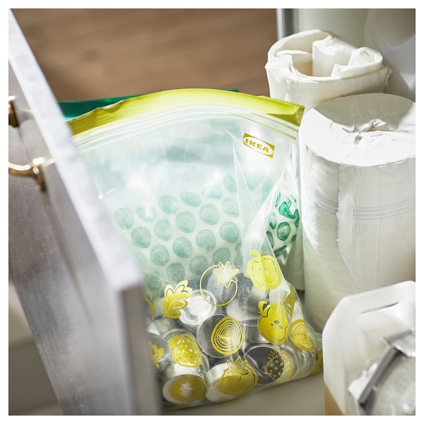 IKEAs green and yellow reusable storage bag with various designs, placed inside a drawer.