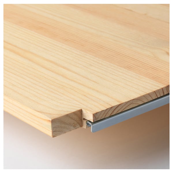 Close-up of wooden table edge, showing sturdy pine wood texture and metal support, highlighting quality and craftsmanship.