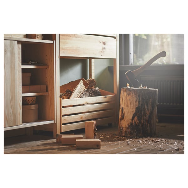 A wooden storage cabinet with shelves containing boxes and a crate of firewood with an axe.