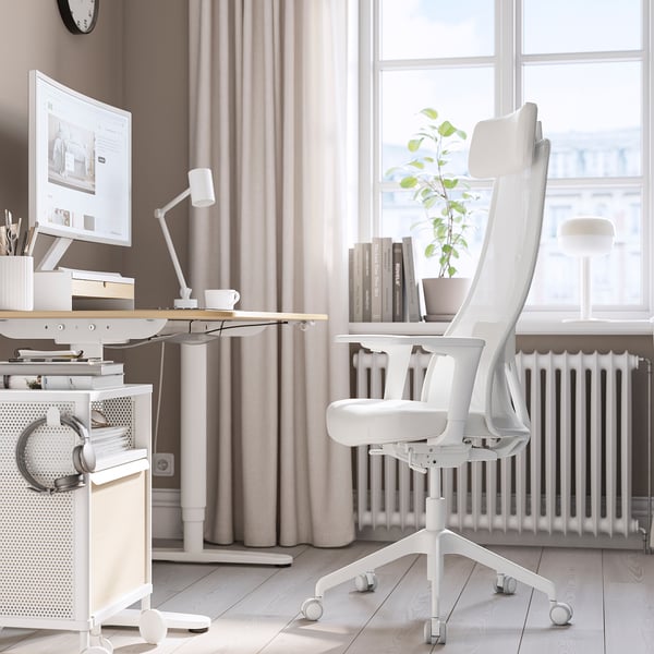 White JÄRVFJÄLLET chair by window, mesh back, leather seat, desk with computer.