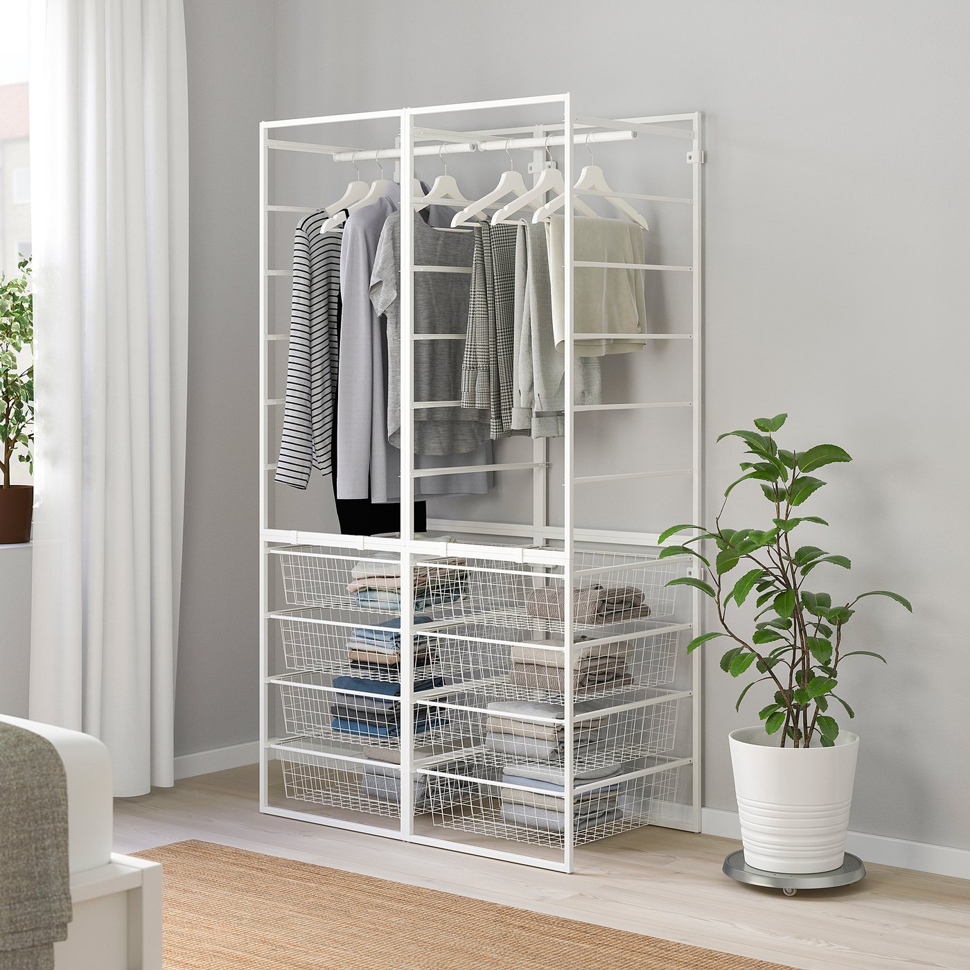 White JONAXEL storage with rods & baskets, holding clothes.