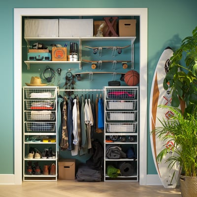 JONAXEL white closet, organised with wire baskets and hangers, blue wall, light wood floor.