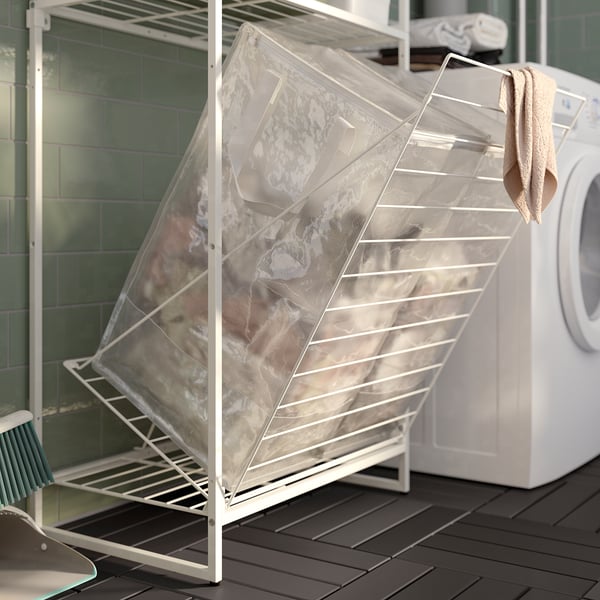 Laundry drying rack with mesh bag on balcony, white steel frame, beige towel.