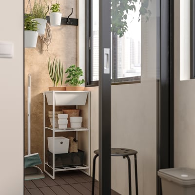 White JOSTEIN storage shelf with plants, containers, indoors near a window, durable steel.