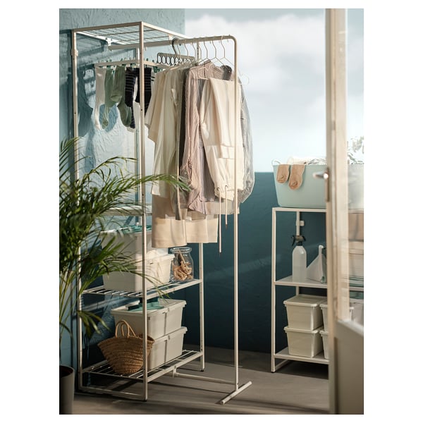 JOSTEIN white drying rack with storage basket, towels, and plant inside.
