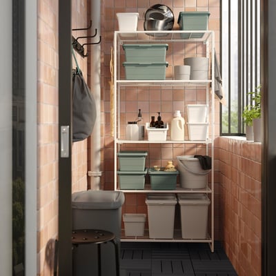 White JOSTEIN shelf with powder-coated steel, red-brown wall, coloured containers, hooks for towels/bags, indoor/outdoor.