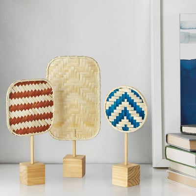 KALKKÄRR: woven bamboo decor in red, beige, and blue, standing on wooden bases. Shapes vary: square, oval, round. Perfect for shelves.