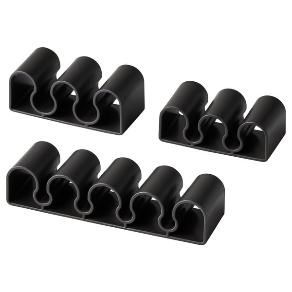Four black KALKSTUFF cable holders, each with three slots for organising cords, displayed against a white background.