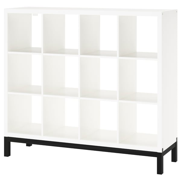 A KALLAX shelving unit in white with a black underframe. It has a modern, square shape with clean lines and multiple open shelves.