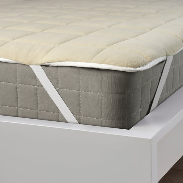 Mattress protector with two-sided colour option: blue for cooling, beige for warmth. Elastic corners for secure fit.