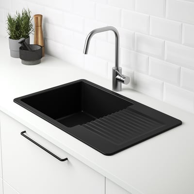 Black quartz sink with drainboard, integrated tap, white countertop.
