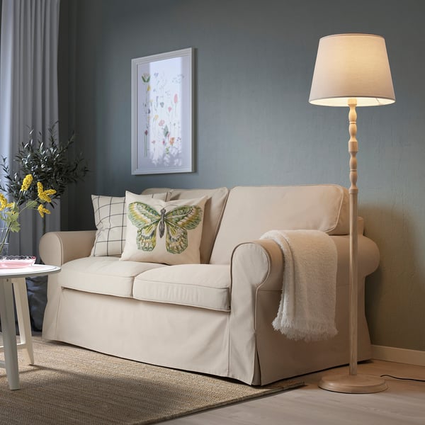 KINNAHULT lamp beside sofa, warm glow.