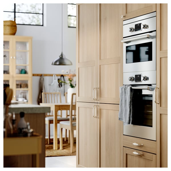 Modern kitchen with wooden cabinets, built-in oven, and dining area.